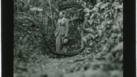 Object Glass slide: a well-dressed man standing amongst plants and trees in a forestcover picture