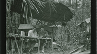 Object Men sitting behind a table under an awning made of palm leaves (British Guiana)cover picture