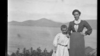 Object Photograph of Máire Ní Chearnaigh of the Blaskets and son Neili, standing against the backdrop of the sea and the [Kerry mainland]cover picture